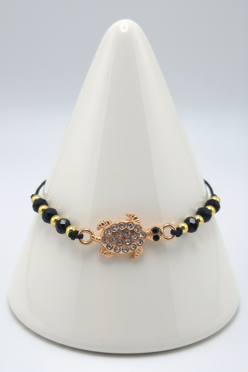 Black turtle bracelet on white porcelain cone stand