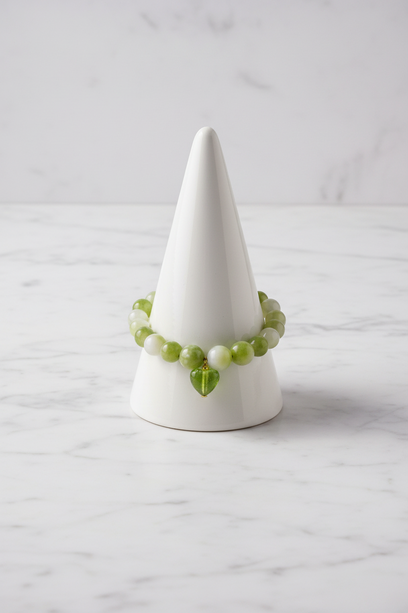 Green heart bracelet on white porcelain cone