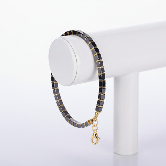 Black Gold Tila Bracelet on White Ceramic Stand