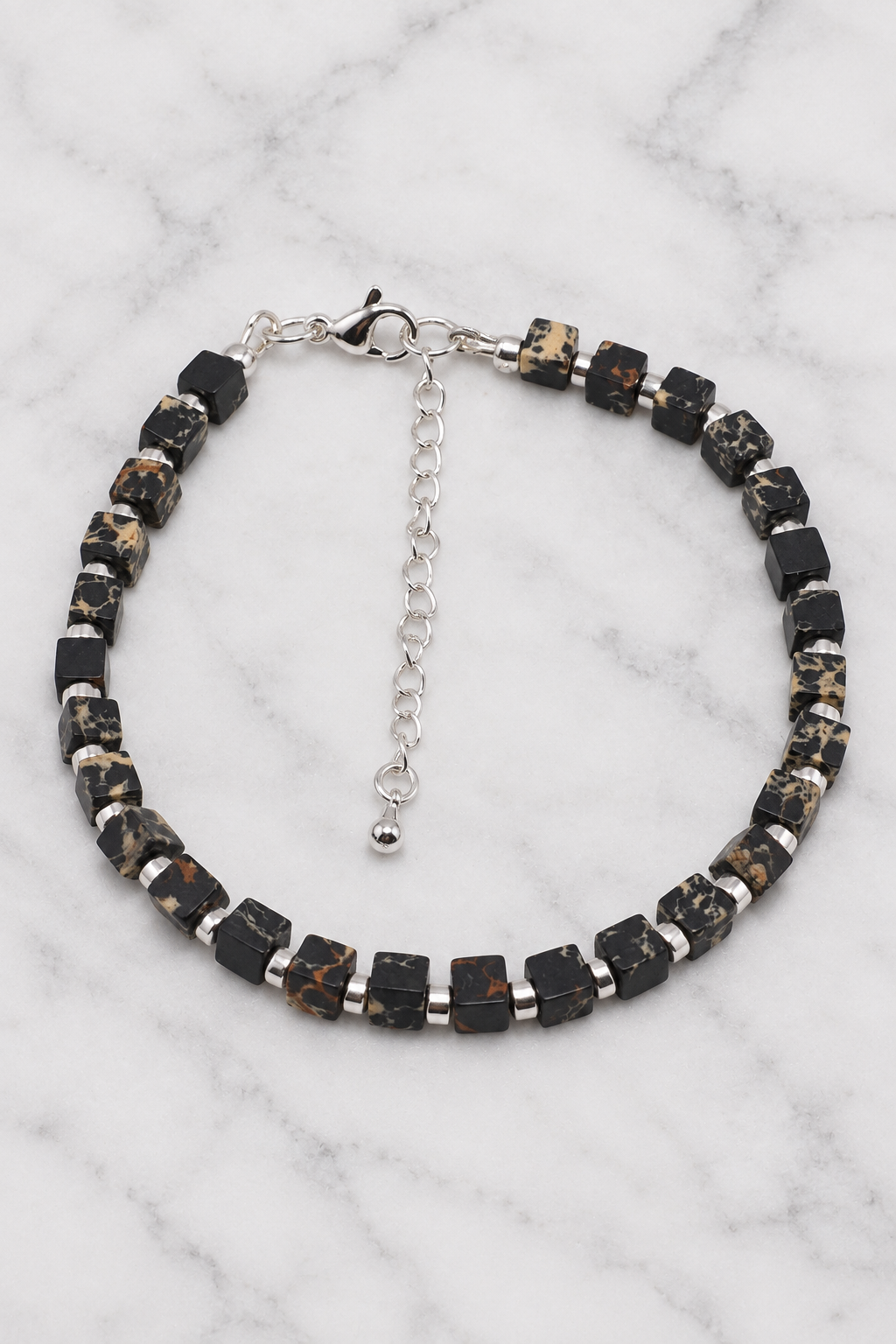 Black marbled cube bead bracelet flat lay on white marble