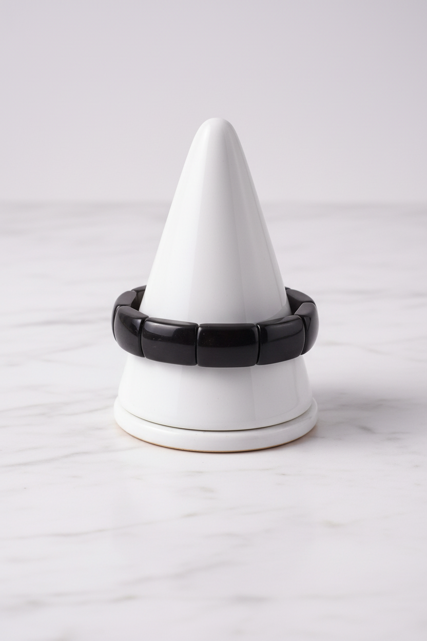 Black rectangular bead bracelet on white porcelain cone