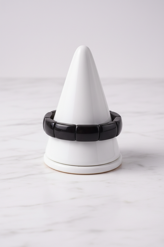 Black rectangular bead bracelet on white porcelain cone