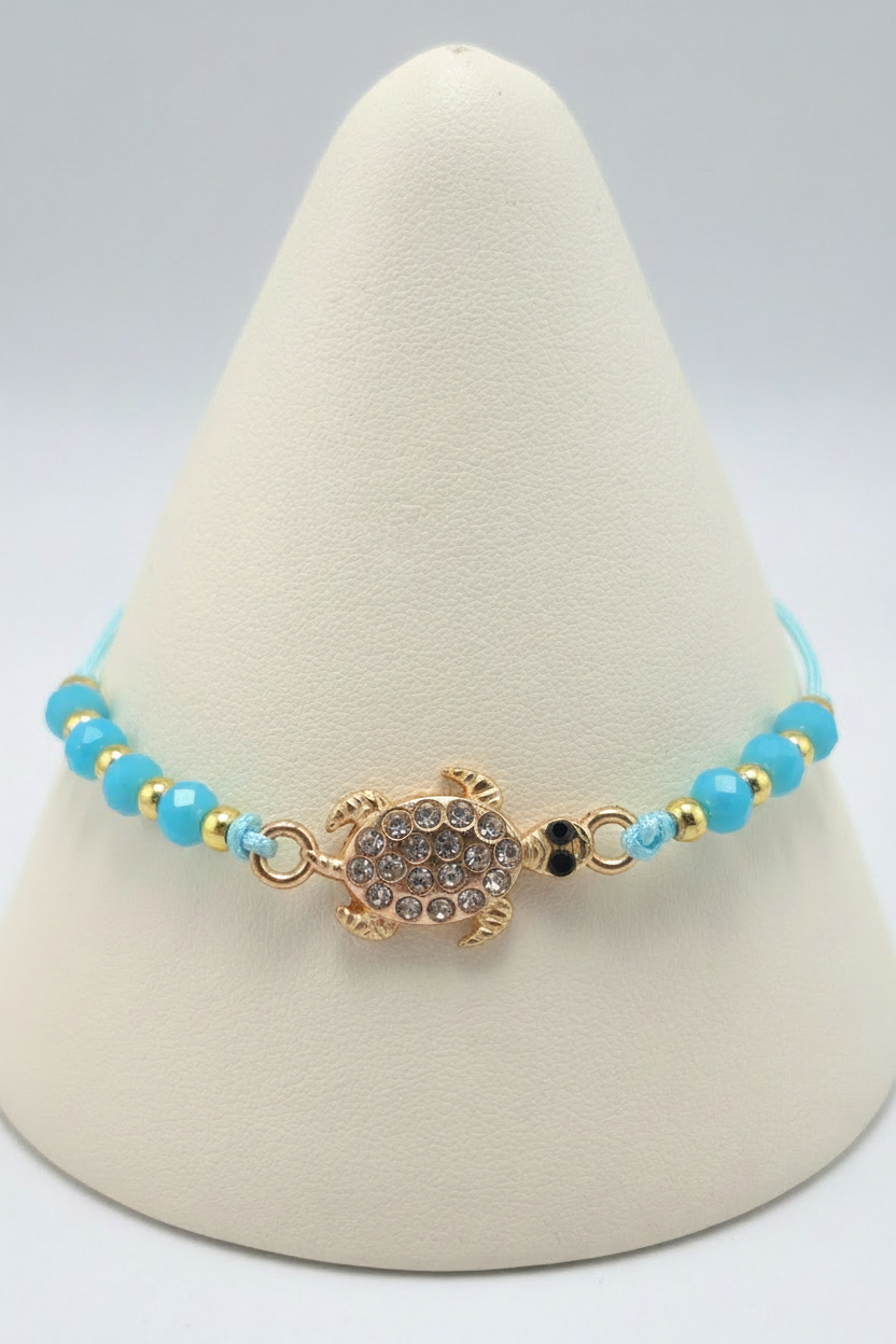 Blue turtle bracelet on white porcelain cone stand