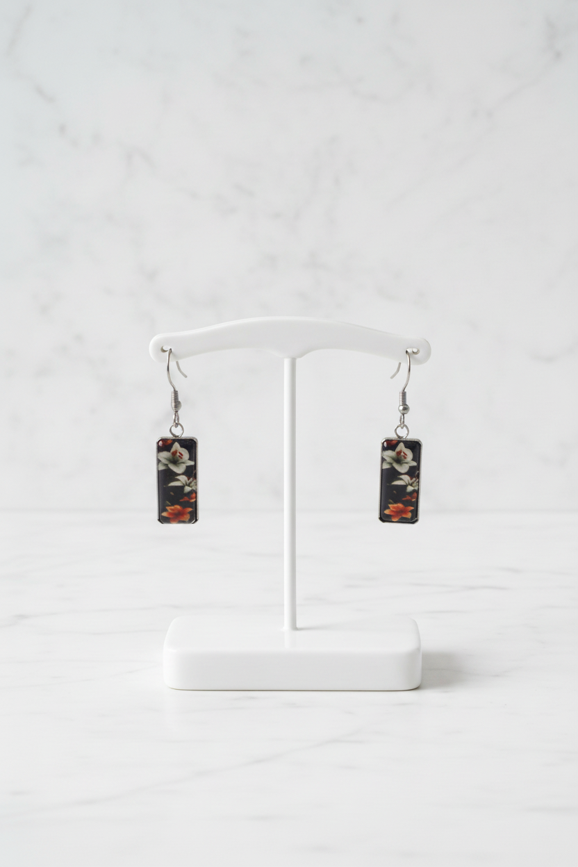 Dark floral earring pair on white porcelain stand