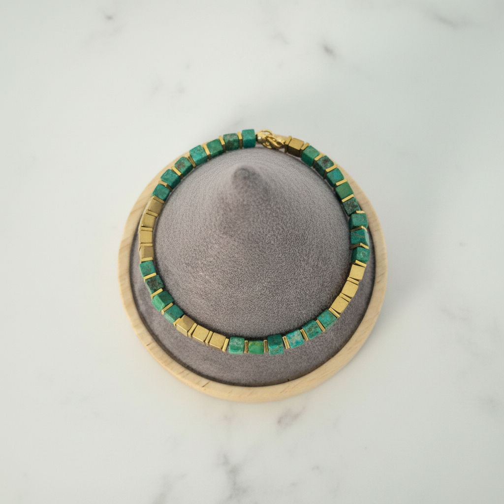 Green bracelet flat lay on white marble