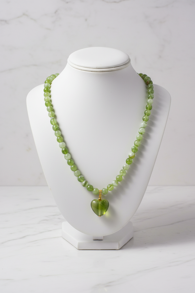 Green heart necklace on white porcelain bust