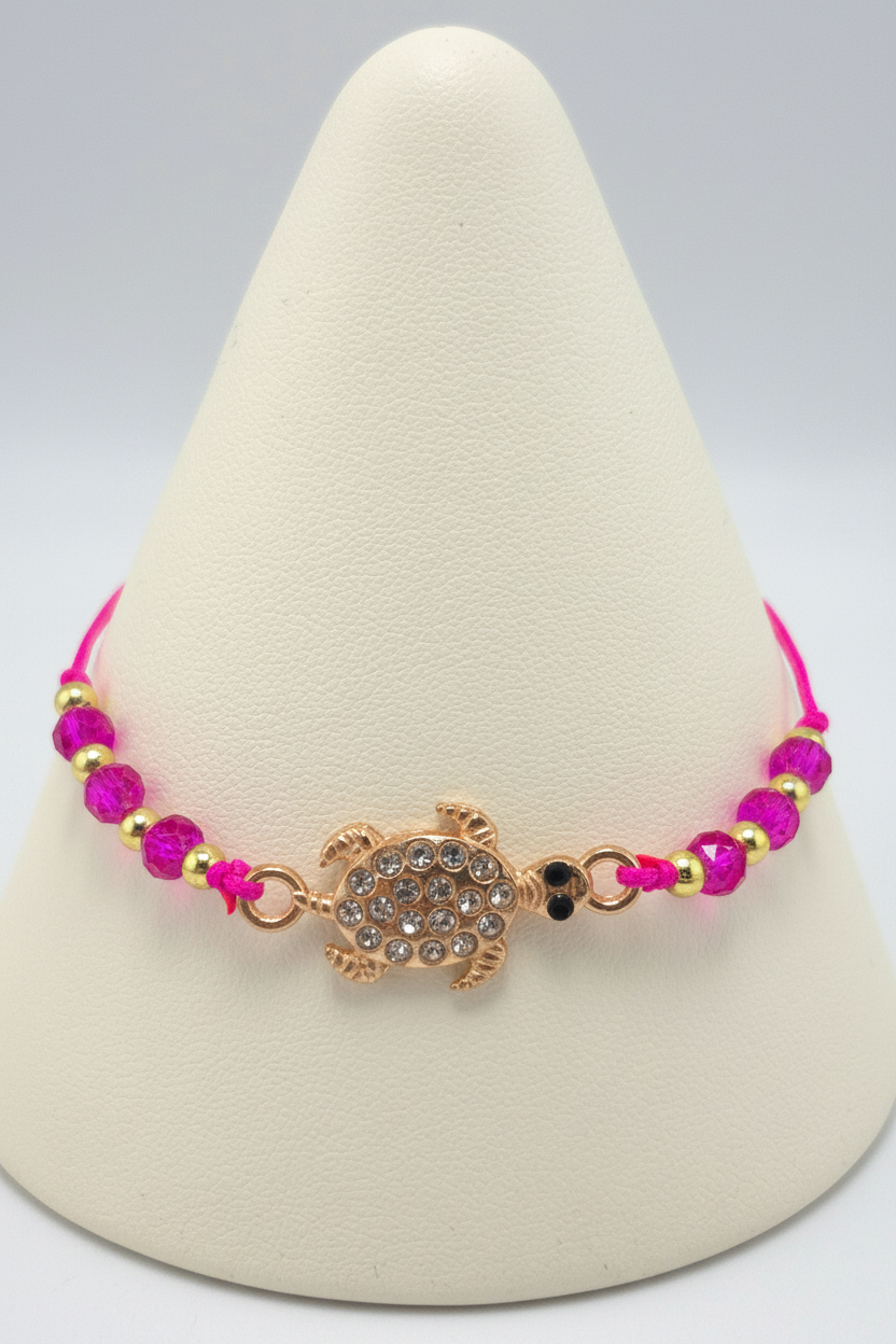 Hot pink turtle bracelet on white porcelain cone stand