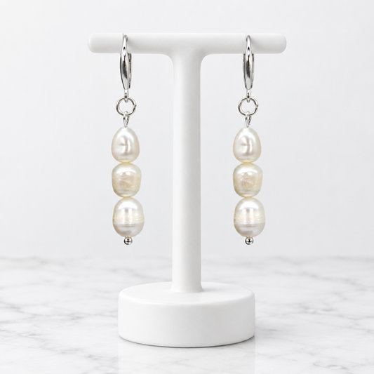 LDJ-0991 round freshwater pearl earrings on a white porcelain display and marble background