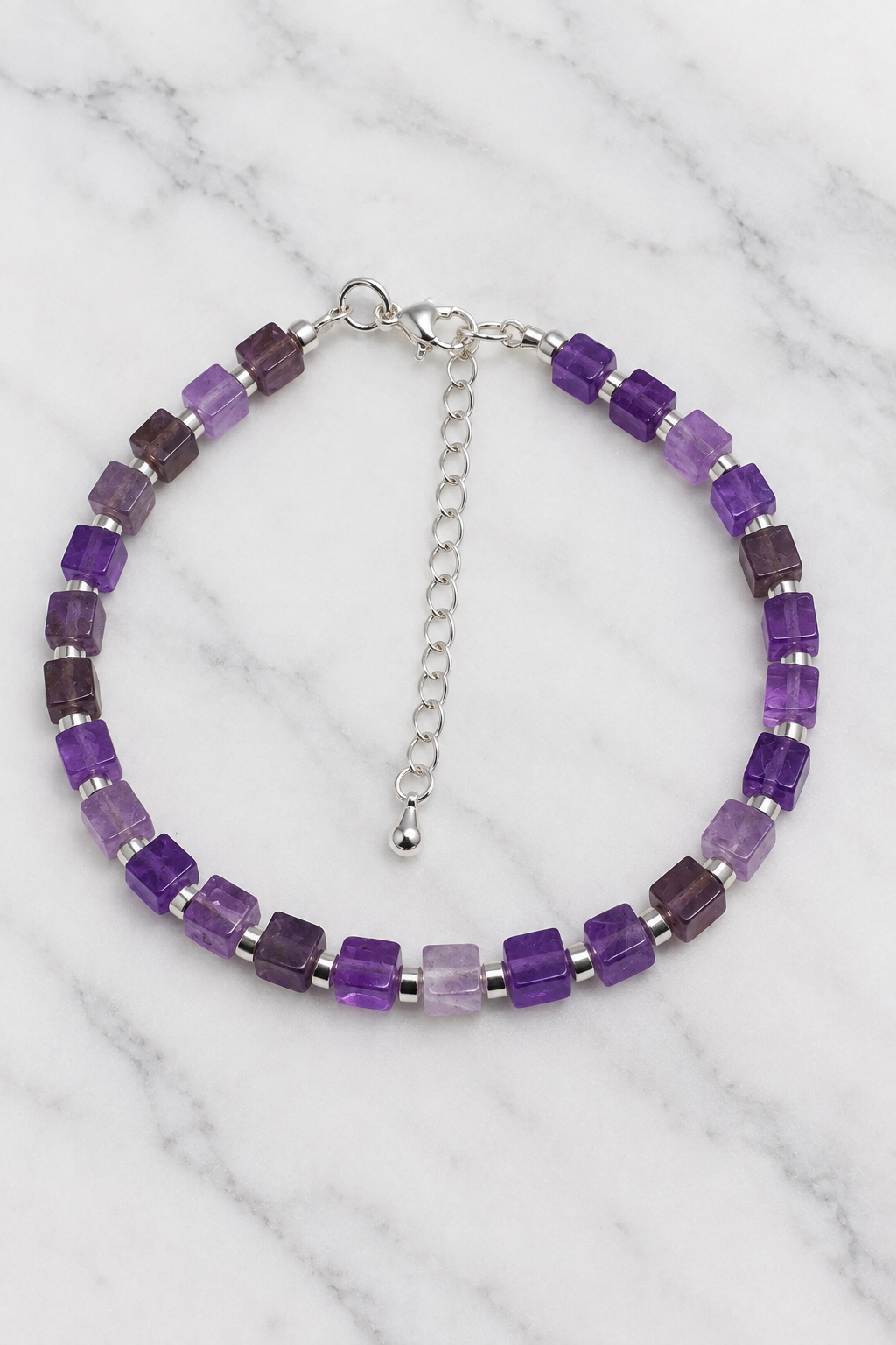 Purple cube bead bracelet with silver spacers flat lay on white marble