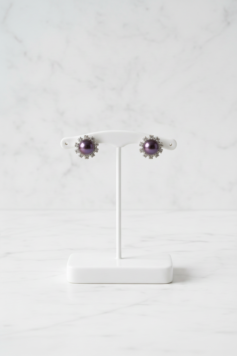 Purple pearl stud earrings on white porcelain stand