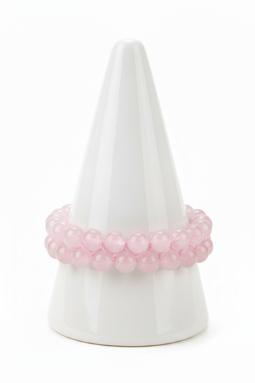 Rose quartz bracelet on white porcelain cone stand