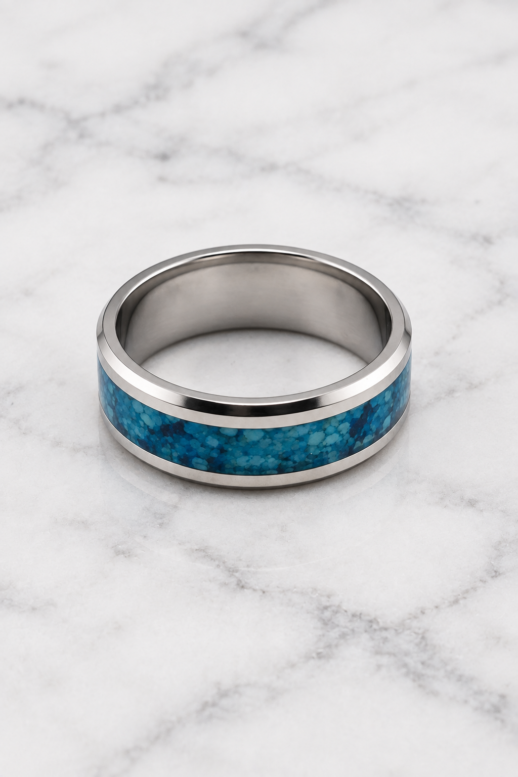 Silver ring with blue inlay flat lay on white marble