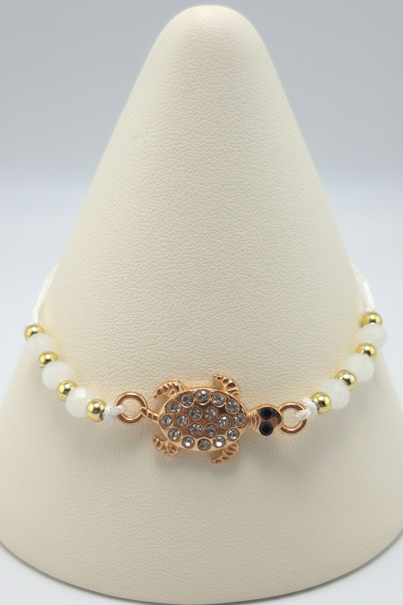 White turtle bracelet on white porcelain cone stand